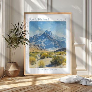 May include: A framed art print of Ras Al Khaimah, United Arab Emirates. The artwork depicts a mountain range under a blue sky, with text at the top and bottom. The print is in a wooden frame.