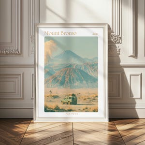 May include: A framed vertical art print featuring a landscape illustration of Mount Bromo in Java, Indonesia. The scene depicts a green off-road vehicle in a sandy desert foreground with volcanic mountains in the background. Text reads Mount Bromo, Java, Indonesia.