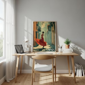 K&ouml;nnte beinhalten: Ein gerahmter vertikaler Wandkunstdruck mit einer stilisierten Illustration einer Person in einem flie&szlig;enden roten Kleid in einer engen Gasse, mit dem Wort SPAIN am unteren Rand. Das Kunstwerk steht auf einem Holztisch mit einem Laptop.