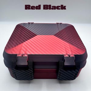 May include: A square storage box with a red and black carbon fiber pattern on the lid. The box features two black latches on the front and the text Red Black is printed in dark red above the container against a plain white background.