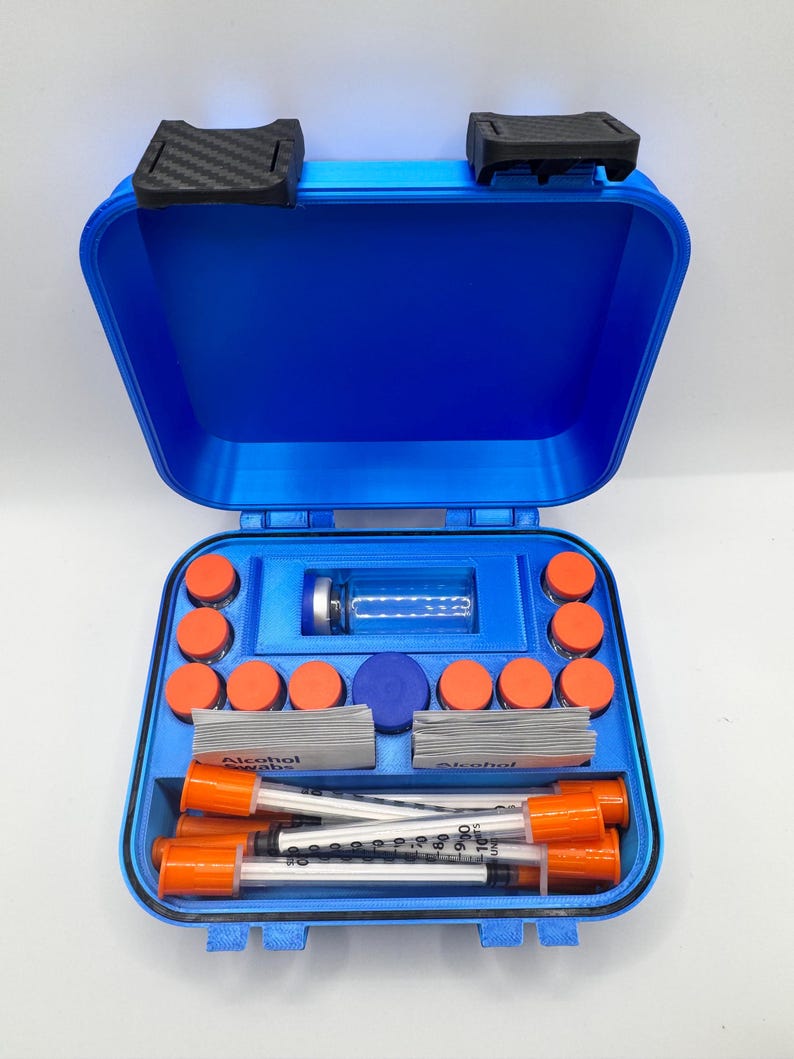 May include: A bright blue, rectangular, hard-shell carrying case with black latches. The interior features custom-molded compartments holding a clear glass vial, ten small orange-capped containers, two stacks of alcohol swabs, and four syringes.