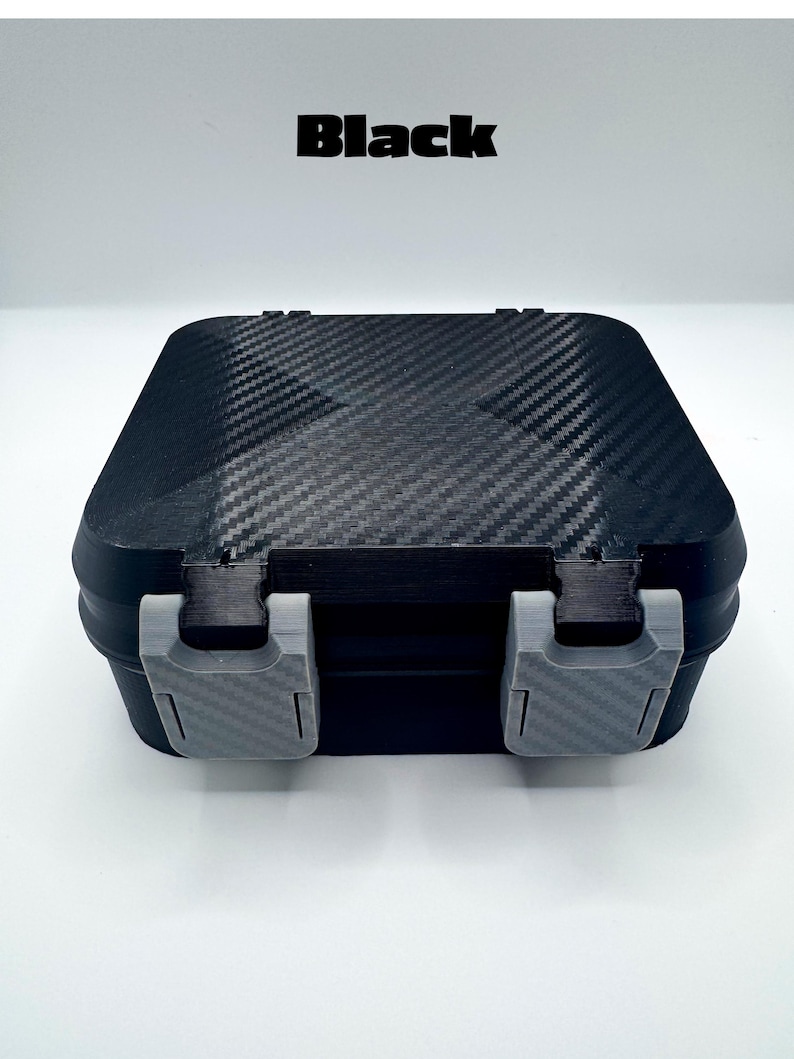 May include: A black rectangular storage box with a carbon fiber texture on the lid and two light gray plastic latches on the front. The word Black is printed in bold black letters above the box, which features a secure, closed design.