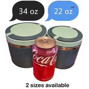 May include: Two insulated containers, one labeled 34 oz and the other 22 oz, sit next to a Cherry Coca-Cola can. The containers are teal with light green lids. Text at the bottom reads "2 sizes available".