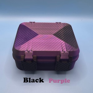 May include: A square storage box with a hinged lid featuring a purple and black carbon fiber pattern. The box has two dark-colored latches on the front. Below the box, the text Black Purple is printed in black and purple font respectively.