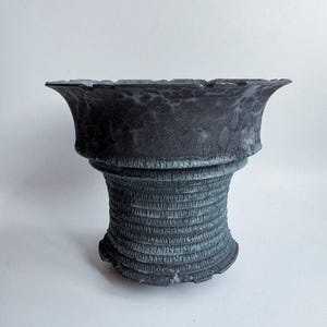 Maceta artesanal de cerámica rústica con textura gris oscuro y acanalada para suculentas, ideal para agaves.