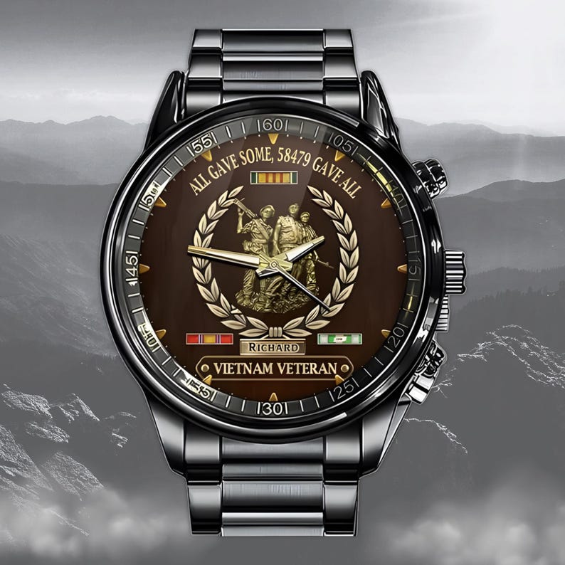 May include: A stainless steel watch with a brown face featuring a gold emblem of soldiers and the text "ALL GAVE SOME, 58479 GAVE ALL". The watch has a black bezel and a metal band. The words "VIETNAM VETERAN" are also visible.