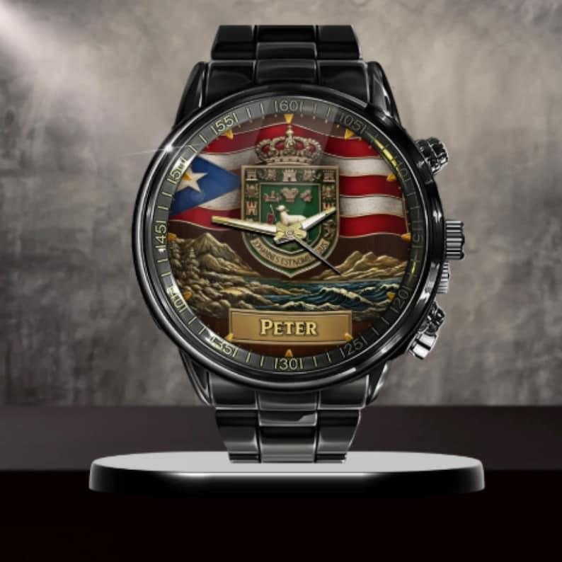May include: A black metal wristwatch featuring a round face with a graphic of the Puerto Rican flag, a coat of arms with a crown and a lamb, and a landscape of mountains and sea. The name Peter is printed in a gold rectangular box on the dial.