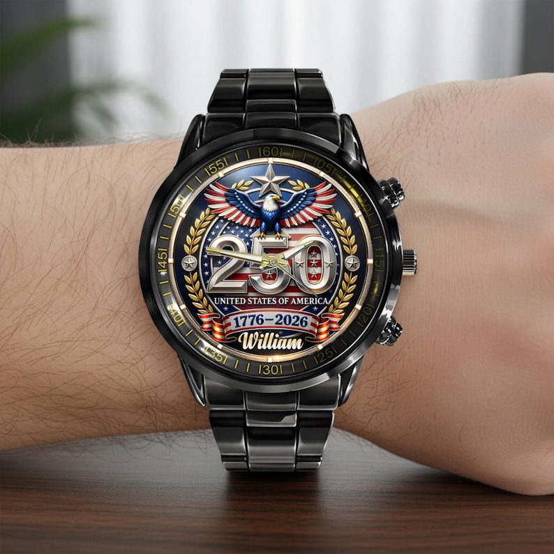 May include: Black wristwatch with a round face featuring a patriotic design. The watch face displays a blue eagle, the number 250, and the text "UNITED STATES OF AMERICA 1776-2026 William". The watch has a black metal band.