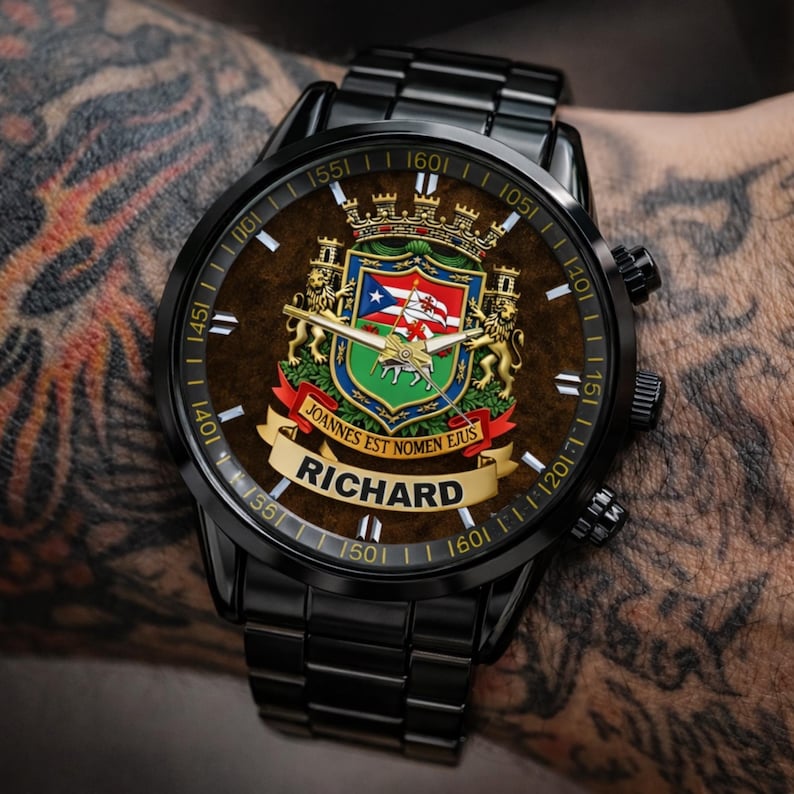 May include: Black wristwatch with a brown face featuring a coat of arms design, a Puerto Rican flag, and the name "RICHARD". The watch has a black metal band and a detailed dial with numbers and markings.