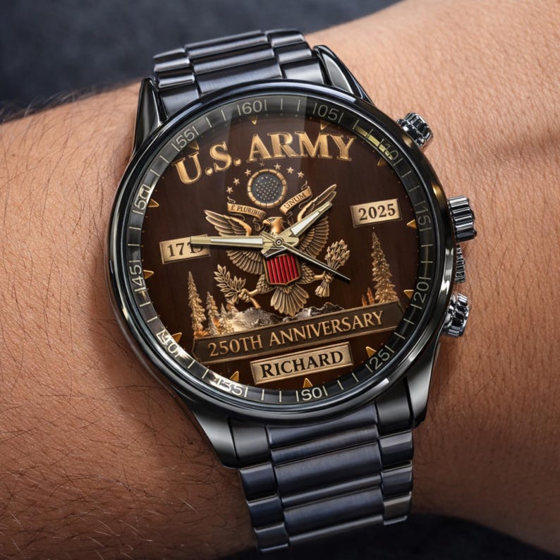 May include: A dark gray wristwatch with a brown face featuring the text "U.S. ARMY" and "250TH ANNIVERSARY". The watch has a metal band and a detailed design with an eagle emblem and the name "RICHARD".