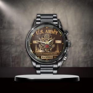 May include: A silver-toned wristwatch with a brown face, featuring the text "U.S. ARMY" and an eagle emblem. The watch commemorates the "250TH ANNIVERSARY" and includes the name "RICHARD". The watch is displayed on a white platform.