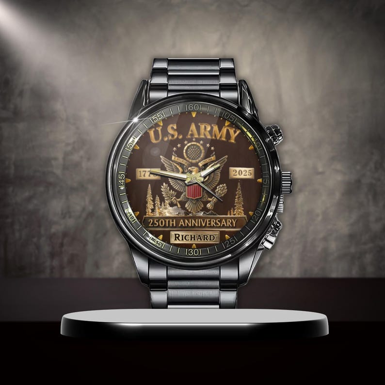 May include: A silver-toned wristwatch with a brown face, featuring the text "U.S. ARMY" and an eagle emblem. The watch commemorates the "250TH ANNIVERSARY" and includes the name "RICHARD". The watch is displayed on a white platform.