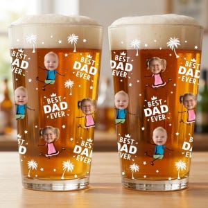 May include: Two pint glasses filled with beer and foam. The glasses are decorated with the text "BEST DAD EVER" and images of children. Palm trees and stars are also printed on the glasses.