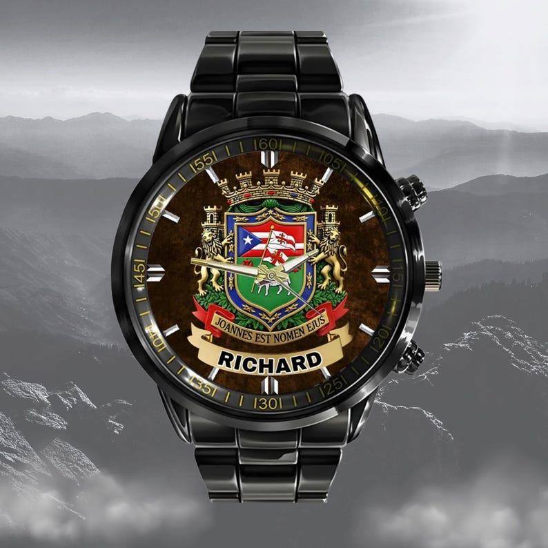 May include: Black wristwatch with a brown face featuring a coat of arms design and the name "RICHARD" in white. The watch has a black metal band and a detailed dial with numbers and markings.