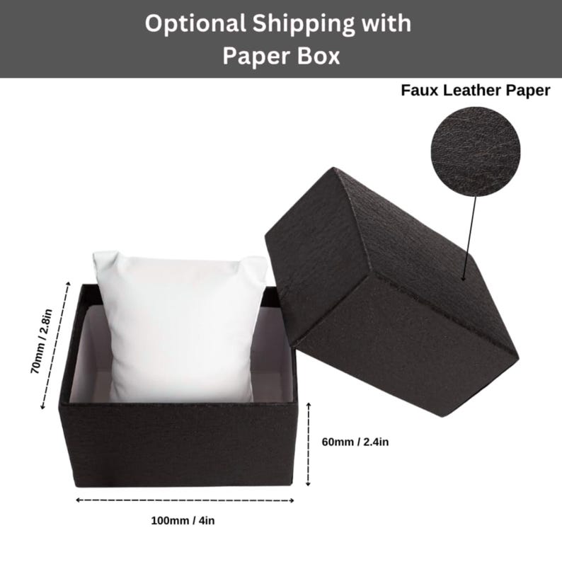 May include: Black faux leather paper watch box with a white pillow inside. The box is open, revealing the interior. The box measures 4 inches long, 2.8 inches high, and 2.4 inches wide.