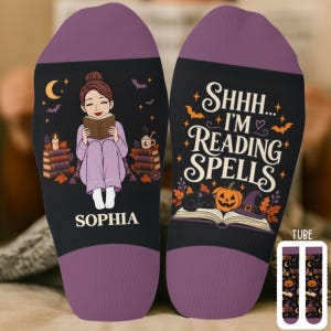 May include: A pair of black socks with purple cuffs. One sock features an illustration of a person reading a book with the name SOPHIA printed below. The other sock displays the text SHHH... I'M READING SPELLS above an open book, a pumpkin, and a cat.