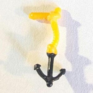 May include: A black anchor charm with a yellow and black plastic chain attached.
