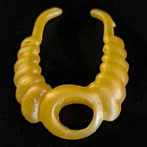 May include: A gold-colored plastic necklace with a twisted rope design. The necklace has a large, round opening in the front.