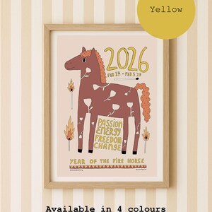A framed art print featuring a brown horse illustration with white flower patterns, the text 2026, FEB 17 - FEB 5 27, PASSION ENERGY FREEDOM CHANGE, and YEAR OF THE FIRE HORSE. The design includes matchstick graphics and is available with yellow text colour.
