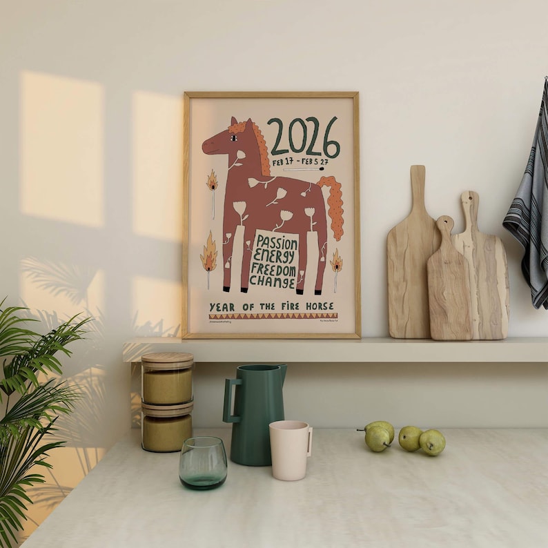 May include: A framed wall art print featuring a brown horse illustration with white flower patterns, flames, and the text 2026, FEB 17 - FEB 5 27, PASSION ENERGY FREEDOM CHANGE, and YEAR OF THE FIRE HORSE on a light beige background.