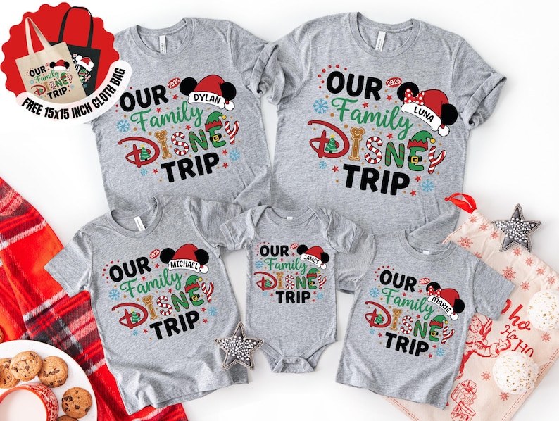 Puede incluir: Una colecci&oacute;n de camisetas grises y un body con el texto "OUR Family DISNEY TRIP" en un dise&ntilde;o colorido. Cada camiseta tiene un nombre en un gorro de Pap&aacute; Noel de Mickey Mouse. Se incluye una bolsa de tela gratuita de 38x38 cm.