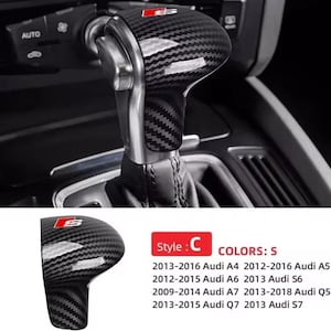 Op de afbeelding: Carbon fiber versnellingspookknop met een rood en zilver logo. De knop is ontworpen voor verschillende Audi-modellen, waaronder A4, A5, A6, A7, Q5, Q7 en S6, S7. De afbeelding toont ook het interieur van de auto.