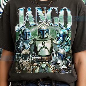 Puede incluir: Camiseta gris oscuro con un diseño de personajes con armadura y el texto "Jango Fett". El diseño utiliza tonos azules y plateados, con efectos de relámpagos. La camiseta la lleva una persona.