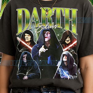May include: Dark gray t-shirt featuring a graphic of Darth Sidious and other characters from the Star Wars saga. The word "Darth Sidious" is printed in a green and yellow font. The shirt has a vintage, distressed look.