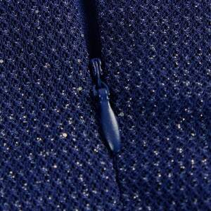 May include: A dark blue fabric with a fine mesh texture and subtle silver glitter particles throughout. A matching dark blue zipper pull is centered vertically, integrated into the seam of the material, showing a smooth, teardrop-shaped design.