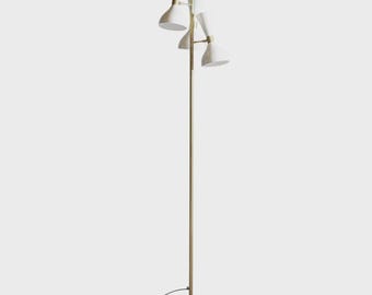 May include: A mid-century modern floor lamp with three white cone-shaped shades. The lamp has a brass-colored pole and accents, and a black base. The lamp is a stylish lighting fixture.