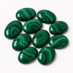 May include: A collection of ten polished oval malachite stones, each featuring distinct, swirling bands of deep forest green and lighter emerald green. These smooth, rounded cabochons display natural concentric patterns across their surfaces.