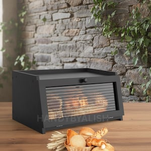 May include: A white ceramic mug with a black handle and the text "But First, Coffee" in a black, handwritten-style font. The mug is on a white surface.