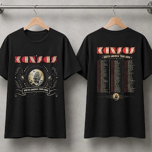 Może przedstawiać: Czarny t-shirt z krótkim rękawem z nadrukiem graficznym. Przód zawiera napis KANSAS, kolistą ilustrację statku oraz North America Tour 2026. Tył zawiera listę dat i miejsc trasy koncertowej pod napisem KANSAS North America Tour 2026.