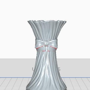 May include: A light gray vase with a ruffled top and a bow tied around the middle. The bow has red trim. The vase has a textured, pleated design. The base of the vase is a darker gray.