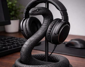 May include: Black snake-shaped headphone stand. The stand is made of a textured material and features a coiled base and a vertical support for the headphones. The headphones are black and rest on the snake's head.