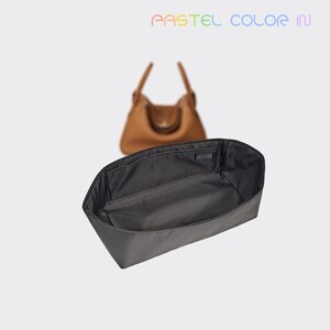 May include: A black handbag organizer with multiple compartments is displayed in front of a brown leather handbag. The organizer is designed to fit inside the handbag. The text "PASTEL COLOR IN" is at the top of the image.