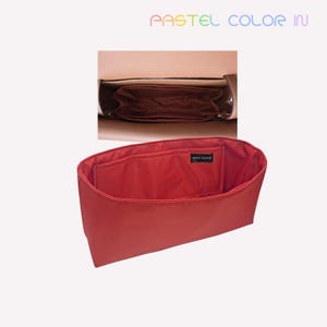 May include: A red bag organiser with a rectangular shape, designed to fit inside a larger bag. The organiser has a pocket on the front and is made of a smooth fabric. The text "PASTEL COLOR IN" is visible at the top.