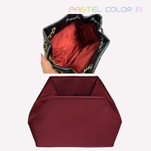 May include: Black quilted leather bucket bag with gold chain straps and a red interior. Below, a burgundy hexagonal cosmetic bag. The text "PASTEL COLOR IN" is visible at the top.
