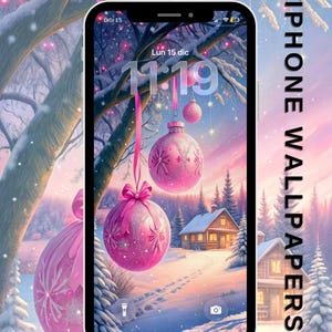 Puede incluir: Un iPhone muestra un fondo de pantalla con temática invernal con adornos navideños rosas colgando de un árbol nevado. La pantalla de bloqueo muestra la fecha y la hora. Las palabras "IPHONE WALLPAPERS" están impresas verticalmente.