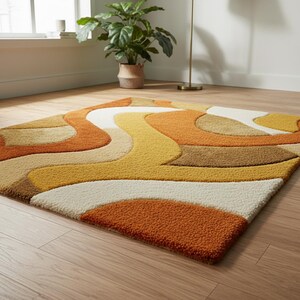 May include: A retro-style area rug with a wavy, abstract design. The rug features a mix of warm colors, including orange, yellow, cream, and brown. The rug is rectangular and has a textured surface, adding visual interest to the floor covering.