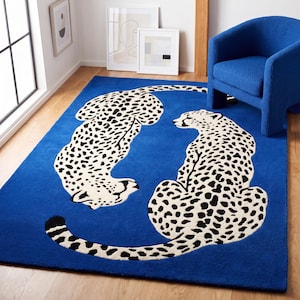 Könnte beinhalten: Ein rechteckiger Teppich mit einem leuchtend blauen Hintergrund und zwei großen, cremefarbenen Leoparden mit schwarzen Flecken. Die Leoparden sind kreisförmig angeordnet, wobei einer nach unten und der andere nach rechts blickt.