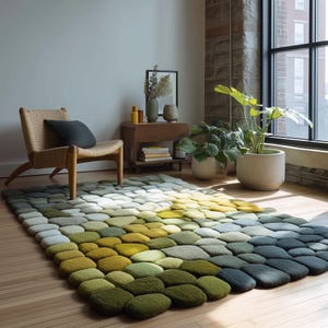May include: A rectangular area rug with a pebble design in shades of green, yellow, and blue. The rug is placed on a hardwood floor, with a chair, side table, and plants in the background. The rug's dimensions are approximately 60 inches by 96 inches.
