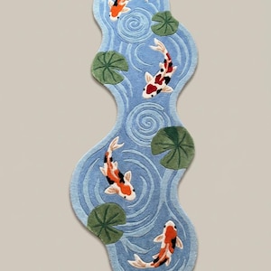 Irregular shaped koi pond runner rug with orange koi fish and green lily pads on light blue background