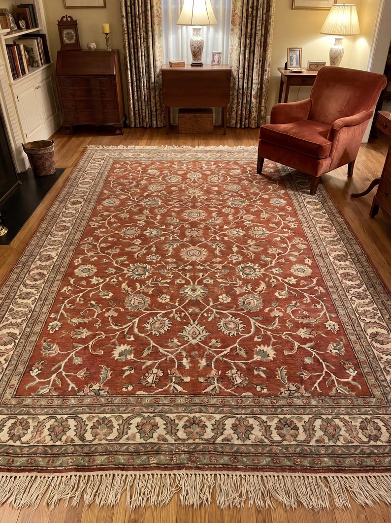 Hand knotted Persian style rug with rust base and floral vine pattern in traditional living room setting