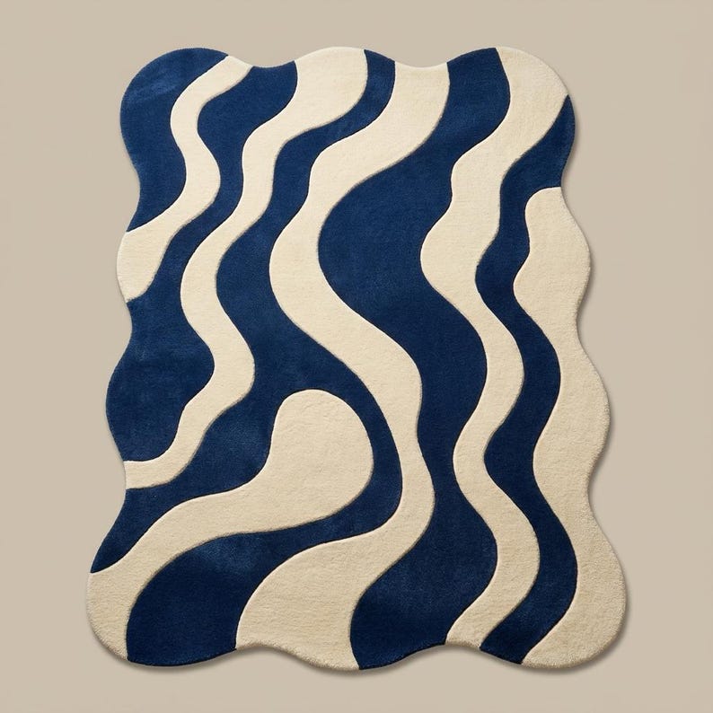 Unique shaped wavy rug in navy and cream tones, styled in a cozy living room with modern furniture and wooden flooring.