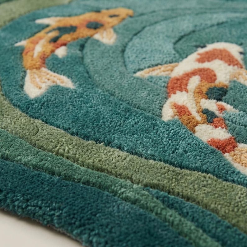 Close-up of dense wool hand-tufted pile showing sculpted carved texture and soft fiber surface in teal and sage tones.