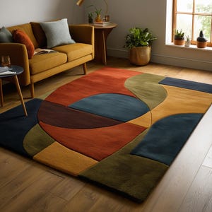 May include: A large, colorful area rug with an abstract geometric design. The rug features a mix of shapes in shades of red, orange, blue, green, and brown. It is placed on a hardwood floor, and the room includes a mustard-colored sofa.