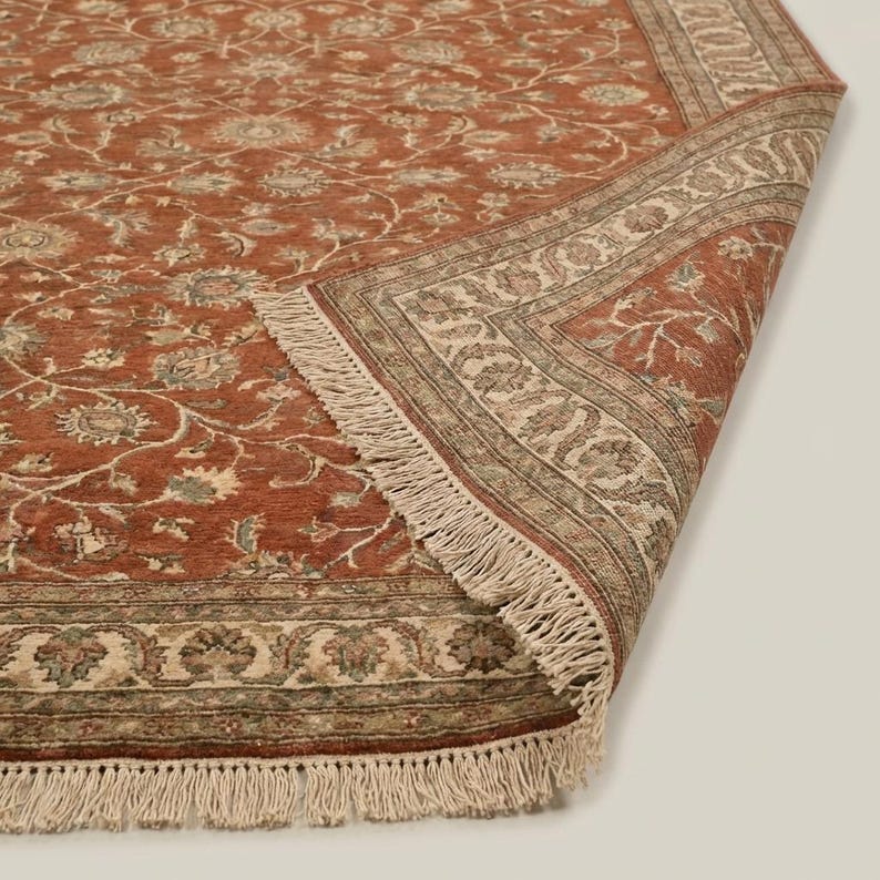 Artisan handmade rug with Persian inspired floral motifs and muted sage and beige accents