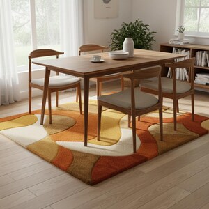 May include: A dining room set featuring a rectangular wooden table and four wooden chairs with beige cushions. A colorful rug with an abstract design in shades of orange, yellow, and brown is beneath the table and chairs.