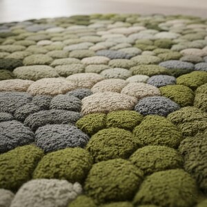 Round botanical rug inspired by moss and stones in neutral tones.